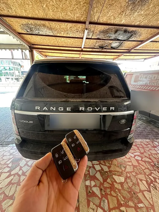 Range Rover aracının önünde tutulan iki otomobil anahtarı
